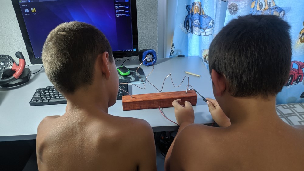 My son and his friend playing the wire loop game